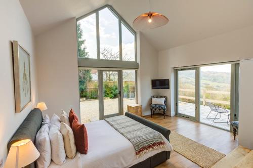 a bedroom with a large bed and glass windows at Cheltenham View Lodge in Cheltenham