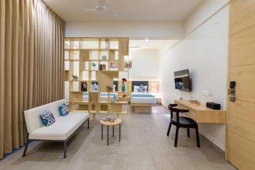 a living room with a couch and a bedroom at Iris Suites in Bangalore