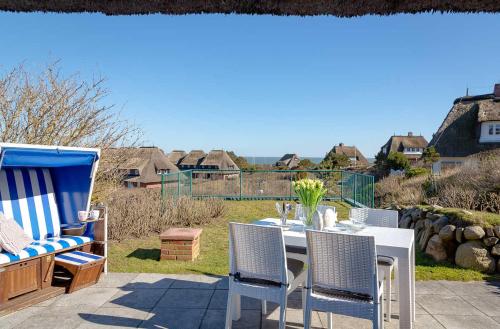 een tafel en stoelen op een patio bij Haus Meerblick in List