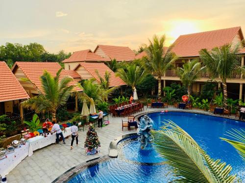a group of people walking around a pool at a resort at Golden Topaz Phu Quoc Resort in Phu Quoc