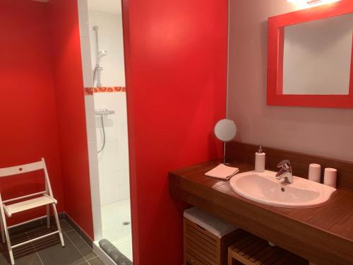 ein Badezimmer mit einem Waschbecken und einer roten Wand in der Unterkunft Les Terrasses de Rochetaillée in Rochetaillée