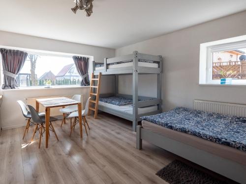 a bedroom with two bunk beds and a table and chairs at Kwatera Karkonoska in Jelenia Góra