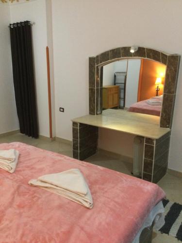a room with two beds and a mirror at The Brown House in Luxor