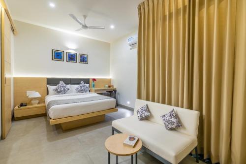 a hotel room with a bed and a couch at Iris Suites in Bengaluru