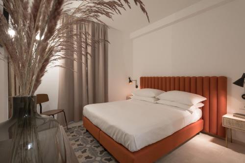 1 dormitorio con 1 cama y un jarrón con una planta en Heraia, en Ragusa