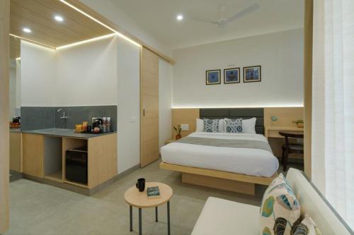 a hotel room with a bed and a kitchen at Iris Suites in Bangalore