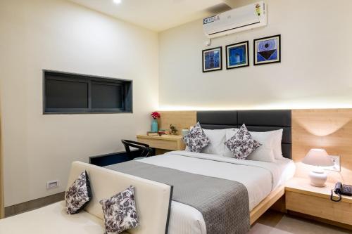 a bedroom with a large bed and a desk at Iris Suites in Bengaluru