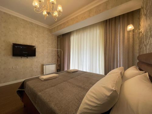a bedroom with a large bed with a television on the wall at Azzure VIP in Baku