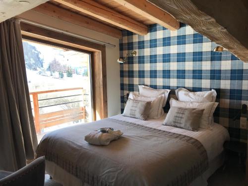 une chambre avec un grand lit avec une grande fenêtre dans l'établissement Hotel La Toviere, à Val dʼIsère