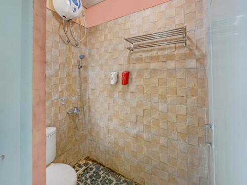 a bathroom with a shower and a toilet in it at OYO 90451 Hotel Roda Mas 1 in Purwokerto