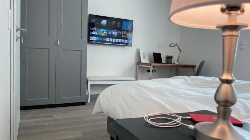 - une chambre avec un lit et une table avec une lampe dans l'établissement Apartment in zentraler Lage zur Dortmunder Innenstadt, à Dortmund