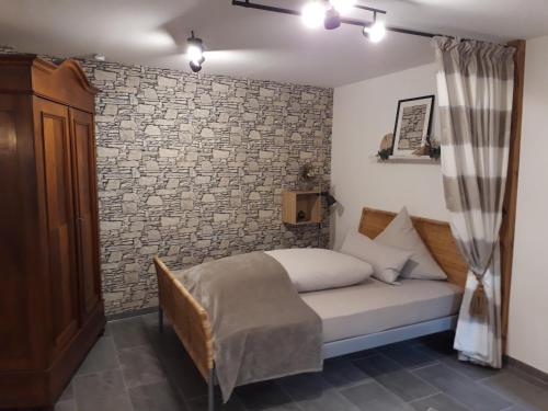 ein Schlafzimmer mit einem Bett und einer Ziegelwand in der Unterkunft Privatzimmer Spahn in Mühlheim in Mühlheim