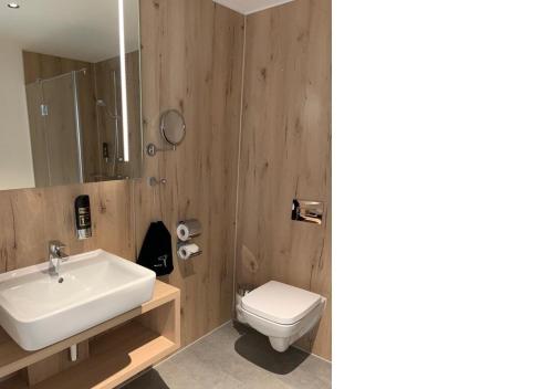 a bathroom with a white sink and a toilet at K6 Seminarhotel in Halberstadt