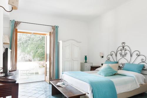 a bedroom with a large bed and a balcony at La Conca del Sogno in Massa Lubrense