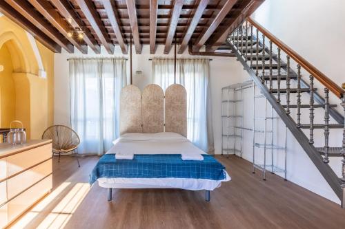 セビリアにあるGreen Apartments Minarete del Salvadorのベッドルーム1室(ベッド1台付)、階段
