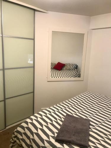 a bedroom with a bed with a mirror on the wall at Central 2 Bed, 2 Bathrooms, Ground Floor Apartment with Parking in Bishops Stortford