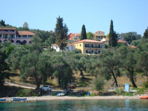 a group of houses on a hill next to the water at Pension Elena in Ágios Nikólaos