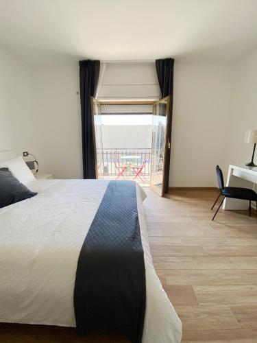 a bedroom with a bed and a view of a balcony at Casa Giulia in Catania
