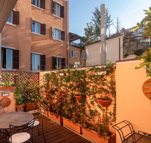 eine Terrasse mit Tischen und Pflanzen an einer Wand in der Unterkunft Hotel Scalinata Di Spagna in Rom