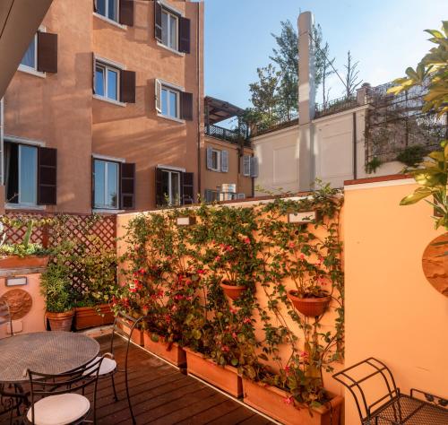 a patio with tables and plants on a wall at Hotel Scalinata Di Spagna in Rome