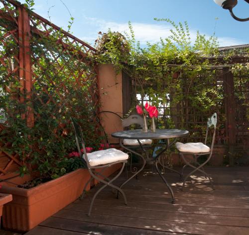 eine Terrasse mit einem Tisch, 2 Stühlen und einer Pergola in der Unterkunft Hotel Scalinata Di Spagna in Rom