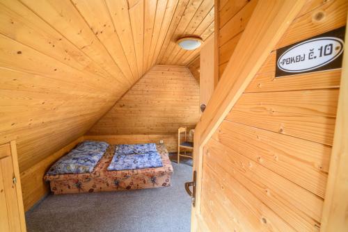 um quarto no sótão com uma cama num quarto de madeira em Chata Šumava em Hojsova Stráz