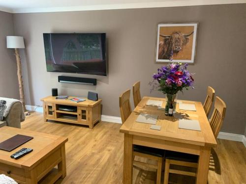 a living room with a table with a vase of flowers on it at In the heart of Inverness in Inverness