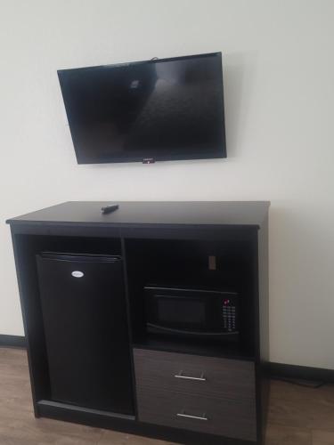 a black entertainment center with a flat screen tv on a wall at Econo Lodge Inn & Suites Downtown San Antonio Riverwalk Area in San Antonio
