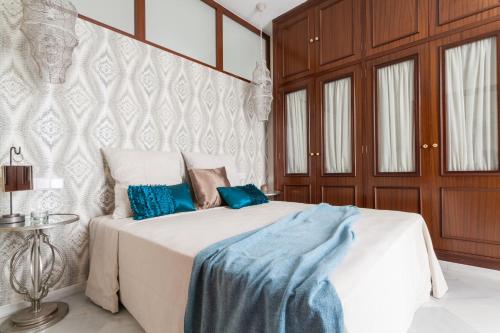 セビリアにあるGreen-Apartments Sierpesのベッドルーム1室(青い毛布付きのベッド1台付)