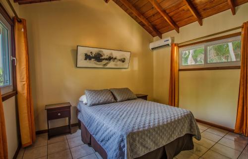 1 dormitorio con cama y ventana en Relaxing Tropical Cabin en Roatan