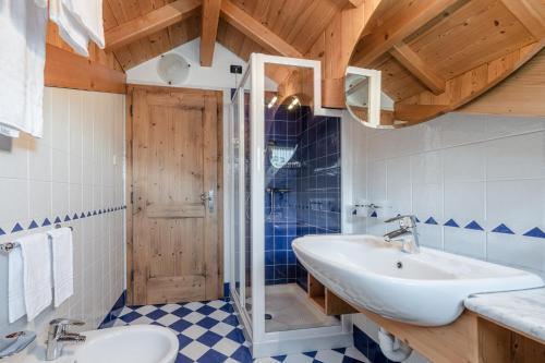 uma casa de banho com um lavatório e um chuveiro em Maso Margherita em Commezzadura
