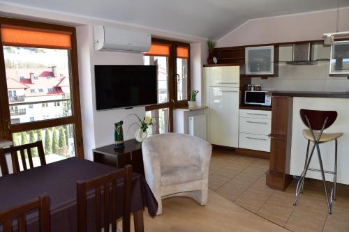 a kitchen and dining room with a table and a kitchen at Apartament Sonata in Krynica Zdrój