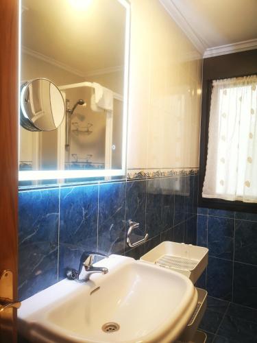 a bathroom with a sink and a mirror at CLOIS, luanco centro in Luanco