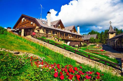 a house with a garden and a clock tower in front of it at Staraya Melnitsa Holiday Park in Solnechnoye