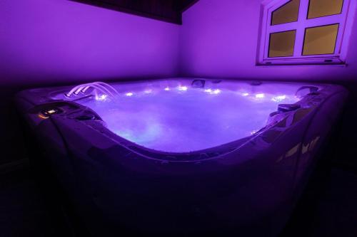 una vasca da bagno viola in una stanza con finestra di Villa Ventus, 40sqm private pool & hot tub! a Roussospítion