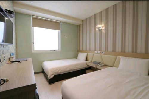高雄的住宿－兆舍行旅，酒店客房设有两张床和窗户。