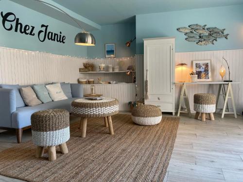 een woonkamer met een bank en een tafel en stoelen bij Hotel du Centre - Chez Janie in Roscoff