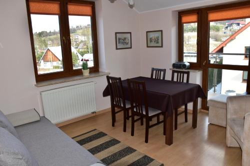 a living room with a table and chairs and a couch at Apartament Sonata in Krynica Zdrój