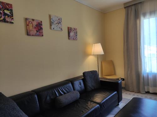 a living room with a black couch and a window at Hotel Giardino in Cannobio
