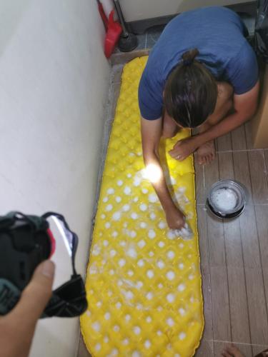 a person bending over a yellow object on the floor with a camera at 228Hostel in Al Ḩamrāʼ