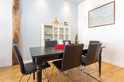 una sala da pranzo con tavolo e sedie neri di Old Town by Bilbao Living a Bilbao