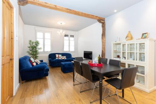 a living room with a table and blue chairs at Old Town by Bilbao Living in Bilbao