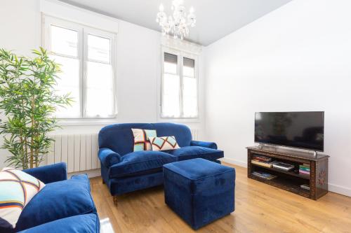 sala de estar con sofá azul y TV en Old Town by Bilbao Living, en Bilbao