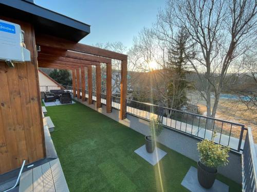 a balcony with a view of a yard with grass at Park Central Tapolca - Apartments in Miskolctapolca
