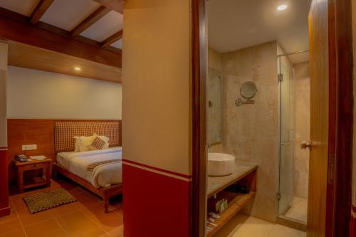 1 dormitorio con 1 cama y baño con ducha en Pahan Chhen - Boutique Hotel, en Katmandú