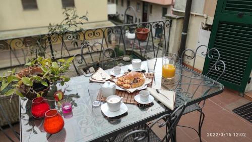 a glass table with a plate of food on a balcony at I love Rapallo La casa AlMar in Rapallo