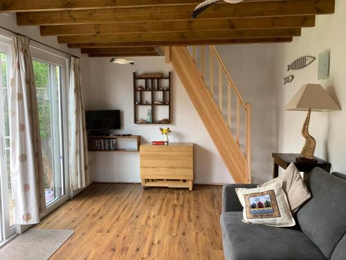 a living room with a couch and a staircase at 'The Wheelhouse' Nautically themed with large sleeping deck in Southwold