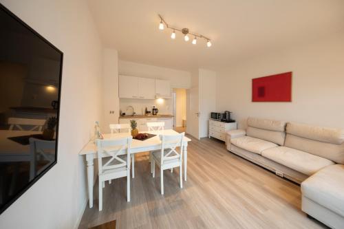 a kitchen and living room with a table and a couch at Apartment direkt am Hafen - mit Terrasse und UHD TV in Dortmund