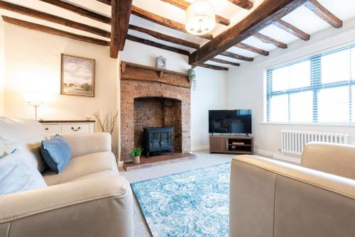 a living room with a couch and a fireplace at Bieldside Cottage in Ollerton