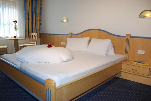 a bed with white sheets and a red star on it at Chasa Monthani in Ischgl